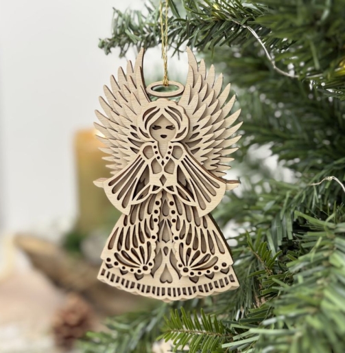 Großer Weihnachtsengel aus Holz mit ausgebreiteten Flügeln, Heiligenschein und verziertem Kleid zwischen grünen Tannenzweigen.