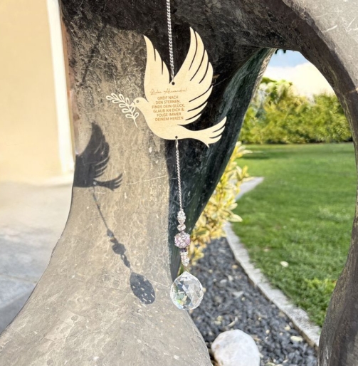 Sonnenfänger Taube personalisiert als Geschenk zur Kommunion mit Kristallkugel im Licht
