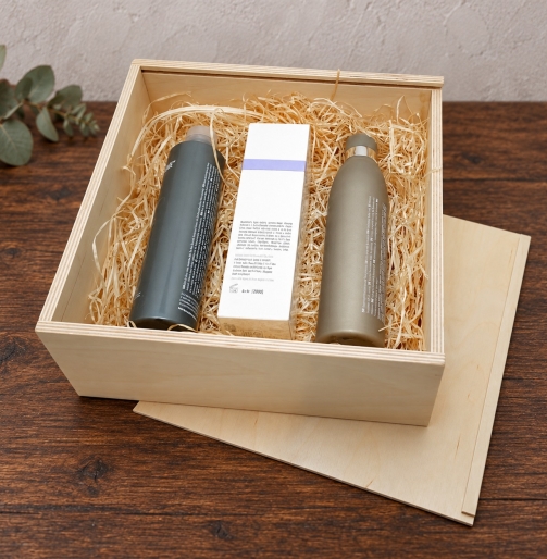 Genussbox aus Holz 24 x 24 x 9 cm mit Pflegeprodukten auf Holzwolle, Schiebedeckel daneben