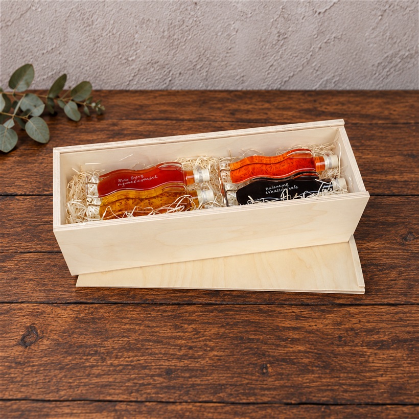 Holzkiste 40 x 12 x 12 cm mit vier Flaschen Essig und Öl auf Holzwolle